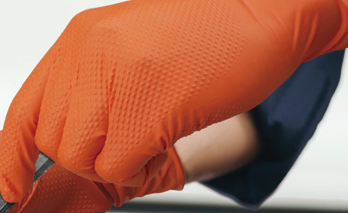 Close crop of the orange glove surface in the supplied workshop image.